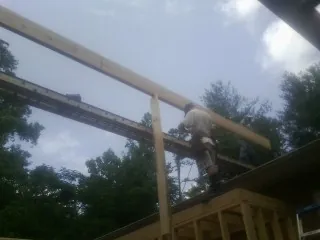 Carpenter setting a ridge beam over a new addition frame — Ice Dam Removal by Roofing Brothers in Waukegan