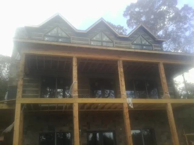 Dormers and porch framing on a large log home under construction — Roof Coating work by our crew in Waukegan