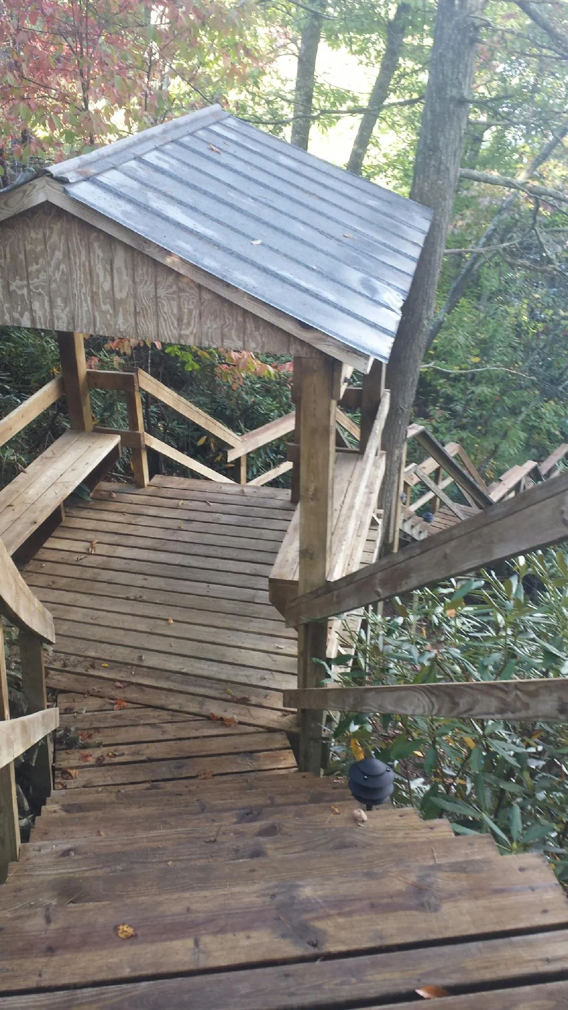 Metal roofed shelter over wooden steps on a wooded walkway — Skylight Repair & Installation work by our crew in Waukegan