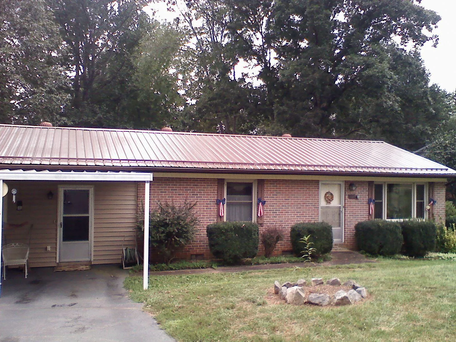 Bronze metal roof and carport on a brick ranch home — Roof Repair work by our crew in Waukegan